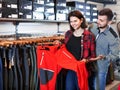 Young couple choosing touristic trousers in sports clothes store Royalty Free Stock Photo