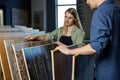 Couple choosing wood texture laminate floor from samples in flooring store for house improvements