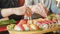 Young couple with chopsticks takes sushi from a plate in a japanese restaurant.