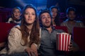 Young couple at the cinema watching an horror movie