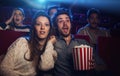 Young couple at the cinema watching an horror movie Royalty Free Stock Photo