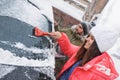 Young couple cleaning snow from car on winter day Royalty Free Stock Photo