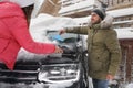 Young couple cleaning snow from car on winter day Royalty Free Stock Photo