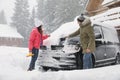 Young couple cleaning snow from car outdoors on winter day Royalty Free Stock Photo