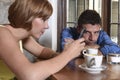 Young couple at coffee shop with internet and mobile phone addict woman ignoring frustrated man Royalty Free Stock Photo