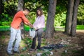 Young couple collect garbage thrown in nature park