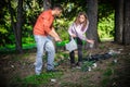 Young couple collect garbage thrown in nature park