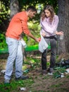 Young couple collect garbage thrown in nature park