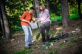 Young couple collect garbage thrown in nature park