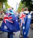 The young couple cover up themselves with Australian flags and walking around town on Australia Day.