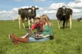 Young couple between the cows Royalty Free Stock Photo