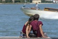 Young couple cuddling while sitting on the pier, Venice, Italy Royalty Free Stock Photo