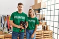 Young couple with cute dog wearing volunteer t shirt at donations stand thinking attitude and sober expression looking self Royalty Free Stock Photo