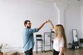 Young couple dancing in the bright living room of their new apartment