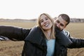 Young couple dancing outdoor through meadow in countryside