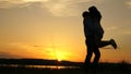 Young couple dancing at sunset on beach. Happy guy and girl waltz in evening in the summer park. Loving man and woman Royalty Free Stock Photo