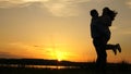 Young couple dancing at sunset on beach. Happy guy and girl waltz in evening in the summer park. Loving man and woman Royalty Free Stock Photo