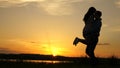 Young couple dancing at sunset on beach. Happy guy and girl waltz in evening in the summer park. Loving man and woman Royalty Free Stock Photo