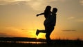 Young couple dancing at sunset on beach. Happy guy and girl waltz in evening in the summer park. Loving man and woman Royalty Free Stock Photo
