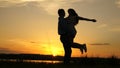 Young couple dancing at sunset on beach. Happy guy and girl waltz in evening in the summer park. Loving man and woman Royalty Free Stock Photo