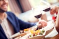 Young couple on date in restaurant sitting eating salad close-up drinking wine cheers blurred Royalty Free Stock Photo