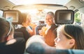 Young couple with daughters eating just cooked Italian pizza sitting in modern car with transparent roof. Happy family moments,