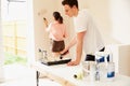 Young couple decorating a room in their house