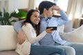 Young couple with divergent interests watch tv together
