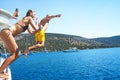 Young couple diving into the turquoise water of the sea from yacht. Royalty Free Stock Photo