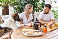 Young couple with dog smiling happy having breakfast at terrace Royalty Free Stock Photo