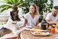 Young couple with dog smiling happy having breakfast at terrace Royalty Free Stock Photo