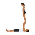 Young couple doing acroyoga. Woman balancing on raised arms of man lying on floor Royalty Free Stock Photo