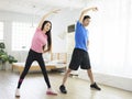 Young couple doing lateral flexion exercise at home