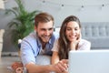 Young couple doing some online shopping at home, using a laptop on floor Royalty Free Stock Photo