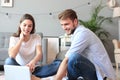 Young couple doing some online shopping at home, using a laptop on floor Royalty Free Stock Photo