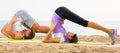 Young couple doing yoga poses sitting on sunny beach Royalty Free Stock Photo