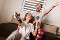 Young couple dressed in pajamas playing video games at home Royalty Free Stock Photo