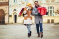 Couple dressed in winter clothing holding gift boxes and shopping bags outdoor