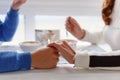 Young couple drink coffee in love clasping hands across the table in cafe, closeup. Romantic background, two cups of coffee and ha Royalty Free Stock Photo