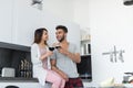 Young Couple Drink Wine In Kitchen, Hispanic Man And Asian Woman Hug Celebration