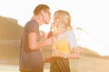 young couple drinking beverage with two plastic straws from one bottle on river beach Royalty Free Stock Photo