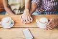 Young couple drinking cappuccino at bar coffee shop - People holding each others hands for tender love moments - Relationship