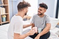 Young couple drinking coffee sitting on bed at bedrooom