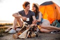 Young couple drinking tea at the bonfire while camping Royalty Free Stock Photo