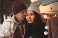 Young couple drinks champagne in winter on the street