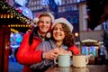 Young couple with drinks on Christmas market