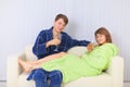 Young couple drinks sparkling wine on sofa Royalty Free Stock Photo