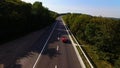 Young Couple Driving Along Country Road In Open Top Conertible Car. Aerial shot. Royalty Free Stock Photo