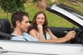 Young couple driving in a silver convertible