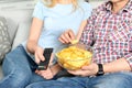 Young couple eating chips while watching TV Royalty Free Stock Photo